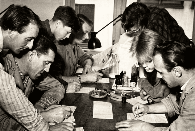 Arkivbilde av en gruppe menn som fyller ut kuponger i 1948.